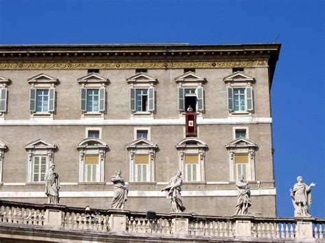 an old building with statues on the balcony