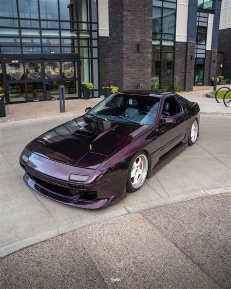 a purple sports car parked in front of a building