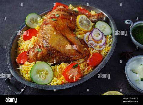 Chicken Kabsa/ kuzhi Mandhi or Mandi Biryani served with yogurt mint chutney Stock Photo - Alamy