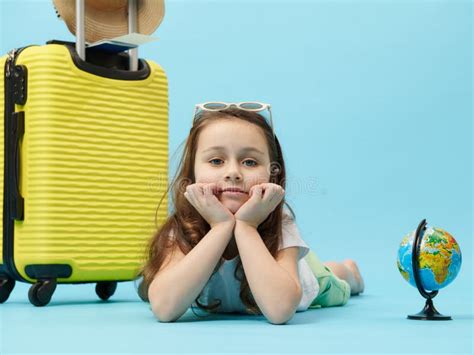 Close-up of an Adorable Little Traveler Child Girl with a Globe and Yellow Suitcase, Isolated on ...