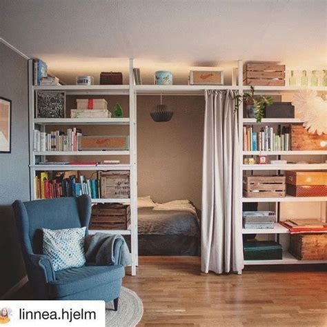 a living room filled with furniture and bookshelves next to a bed in a bedroom