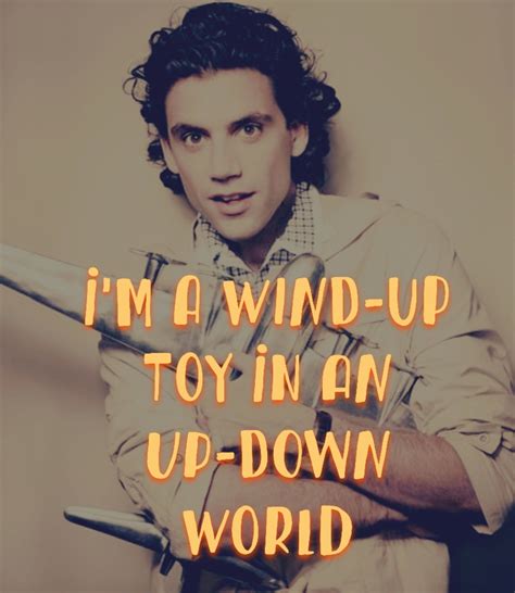 a man holding a toy in his hand with the words i'm a wind - up toy in an upside down world