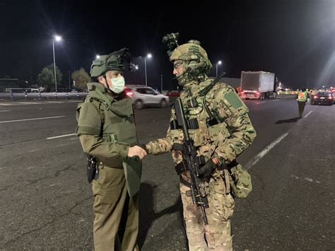 Chilean Police officer (left) and Soldier manning a checkpoint ...