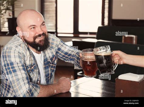 Man cheering with glasses of beer in pub Stock Photo - Alamy