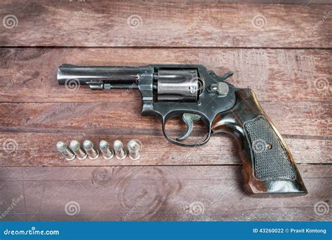 Black Revolver Gun With Bullets Isolated On Wooden Background Stock ...