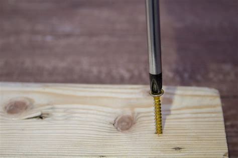 Premium Photo | A screw with a screw in it is being used to screw a screw into a piece of wood.