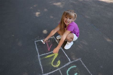 Little Girl Drawing Hopscotch with Chalk on Asphalt Outdoors. Happy Childhood Stock Image ...