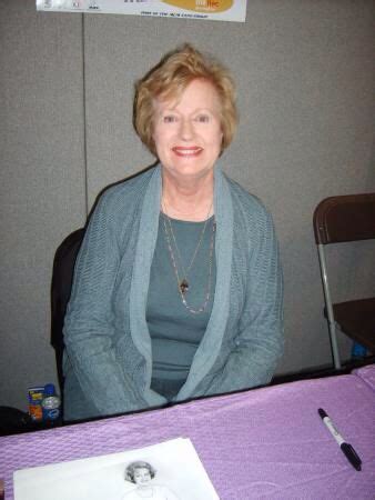 a woman sitting in front of a purple table