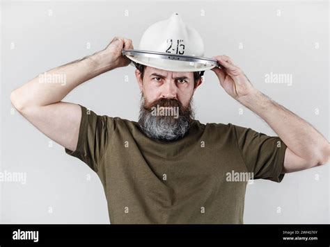 Stern bearded man tries on an old fire helmet. Firefighter in firefighter's helmet Stock Photo ...
