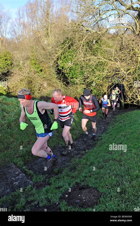 men competing in muddy cross country running race Stock Photo - Alamy