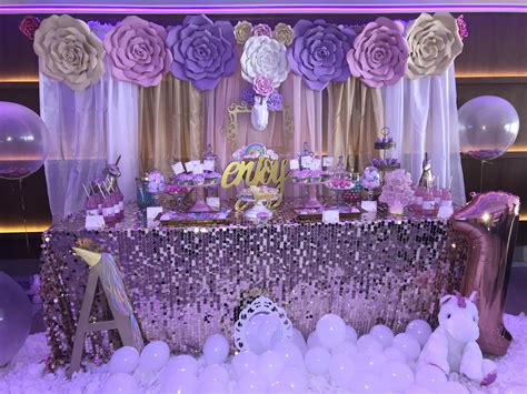a table with balloons, cake and decorations on it