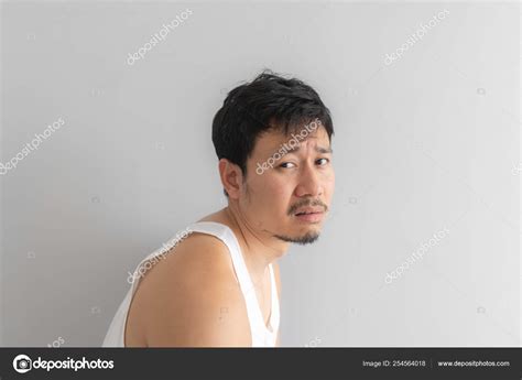 Poor and depressed man wear white tank top on grey background. Concept of desperate life. Stock ...