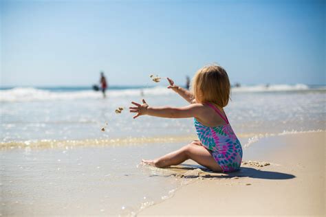 Toddler Girl Sitting on Shore during Day · Free Stock Photo