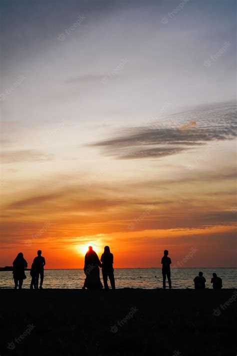 Premium Photo | Group of people enjoying the sunset on the beach ...