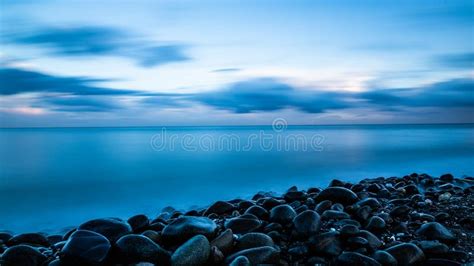 Pebble beach at sunset stock image. Image of reflections - 113951441