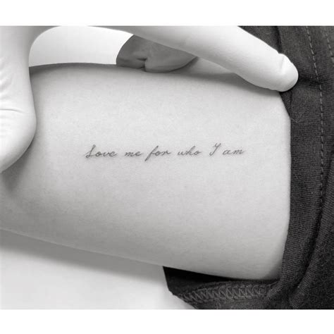 "Love me for who I am" lettering tattoo located on the