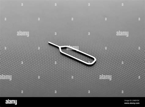 sim card ejector tool on black texture background Stock Photo - Alamy