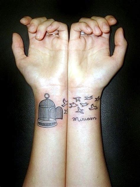 two hands with birds and a birdcage tattoo on them