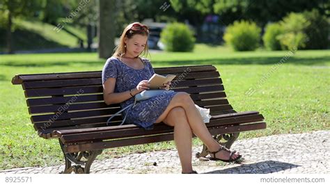 Young Woman Reading A Book And Sitting On A Bench Outside In A Park In Summer, B Stock video ...