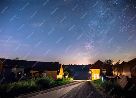 Premium AI Image | village on night starry sky glowing road landscape on shutter speed