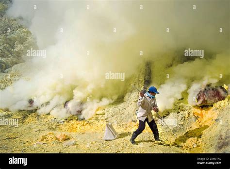 Sulphur miner at work inside the crater of Kawah Ijen volcano in East Java, Indonesia Stock ...
