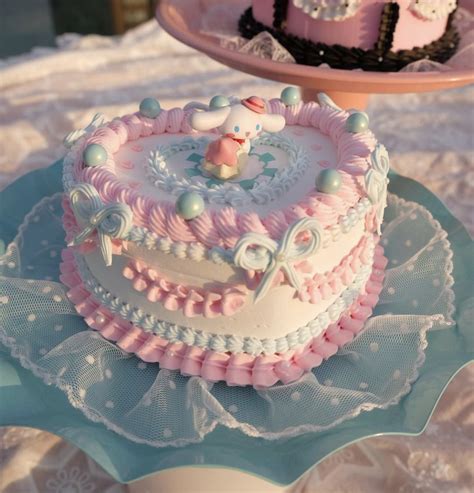 there are two cakes on top of the cake plate, one is pink and white