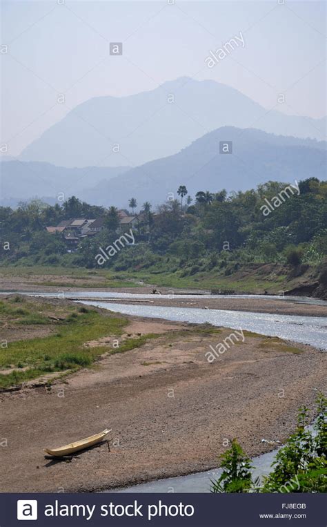 Traditional boat and mountains: Nam Kham River, Luang Prabang, Laos ...