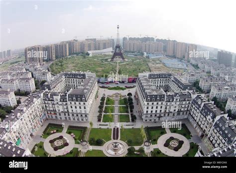 The downsized replication of Eiffel Tower is surrounded by vegetable fields and residential ...