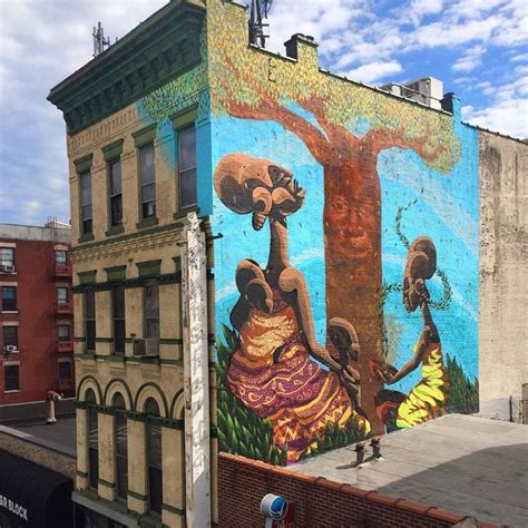 a large mural on the side of a building with two women and a tree ...