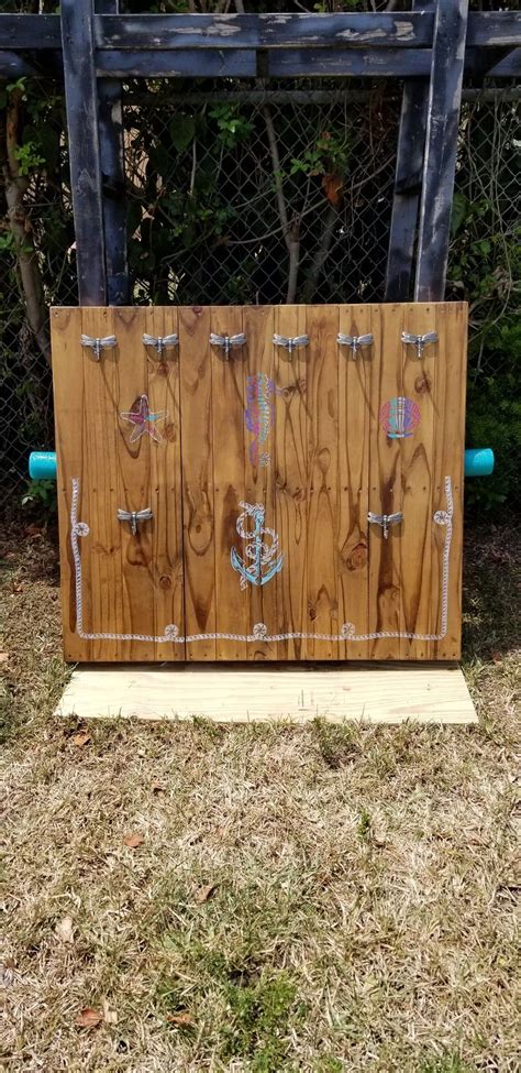 a wooden box with some writing on it in front of a chain link fence and ...