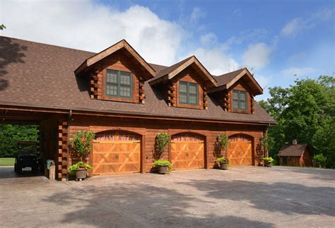 Three car custom garage with living area above is attached to the log home with a breezeway ...