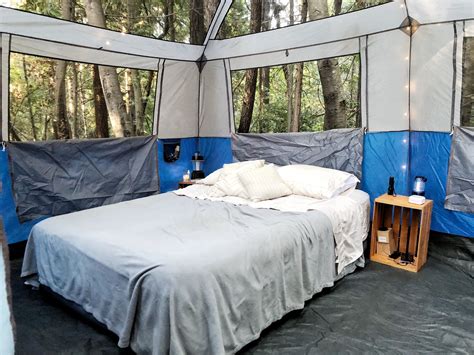 a bed in a tent with blue walls and white sheets on the floor ...