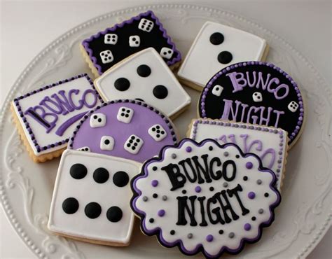 some decorated cookies are on a plate with the words bunco night and dices