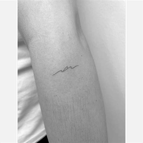 Minimalist shark tattoo on the forearm