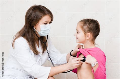 Female doctor examining child with stethoscope at clinic Stock Photo | Adobe Stock