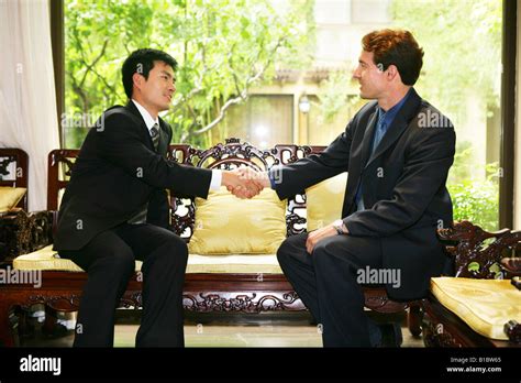 businessmen from different cultures handshaking in hotel room Stock Photo - Alamy