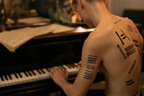 A Tattooed Shirtless Man Playing the Piano · Free Stock Photo