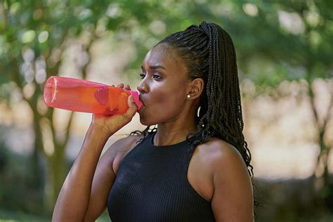 Portrait Of A Beautiful Black Woman Drinking From A Water Bottle Photograph by Cavan Images ...