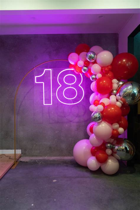 the balloon arch is decorated with red, white and pink balloons that spell out the number eighteen