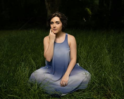 Serene woman in maxi dress sitting on grassy lawn · Free Stock Photo