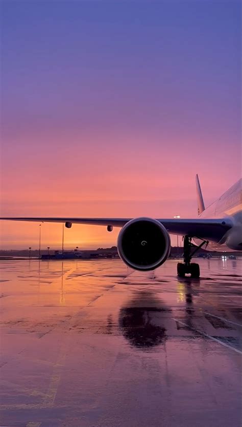 an airplane sitting on the tarmac at sunset