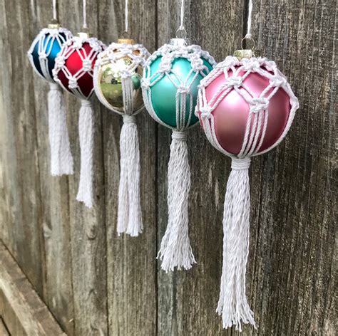 four ornaments hanging from a wooden fence