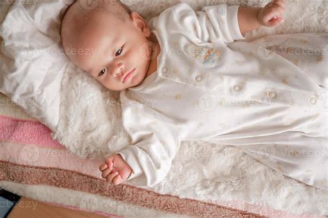 Cute baby boy in a white light bedroom Newborn baby is cute. In bedding for children born ...