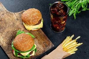 Glass of cold coca cola on a dark background with fries and burger ...