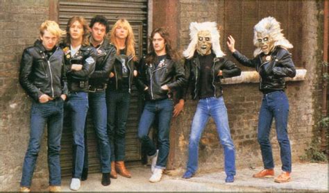 the group of people are posing together in front of an old building with masks on their faces