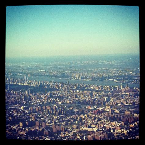 an aerial view of a city with lots of tall buildings and water in the background
