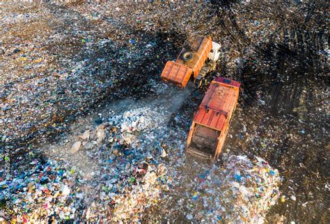 Garbage truck unloads rubbish in landfill. Landfill waste disposal. Garbage dump with waste ...