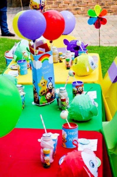 the table is set up with balloons, cups and other items for an outdoor ...