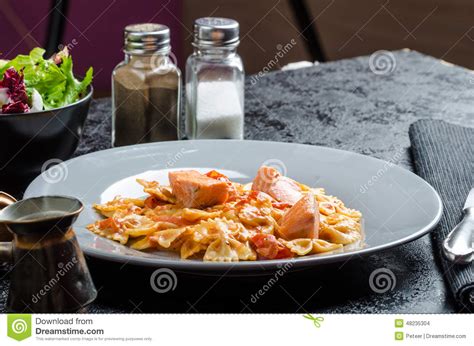 Farfalle with Tomato Sauce and Roasted Salmon Stock Photo - Image of breast, meal: 48235304