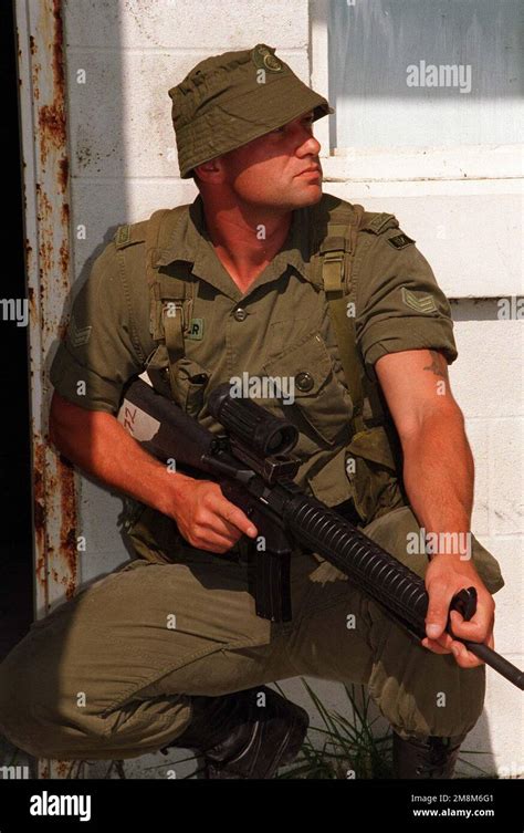 A Canadian soldier armed with a C7A1 assault rifle stands by for the signal to enter the ...